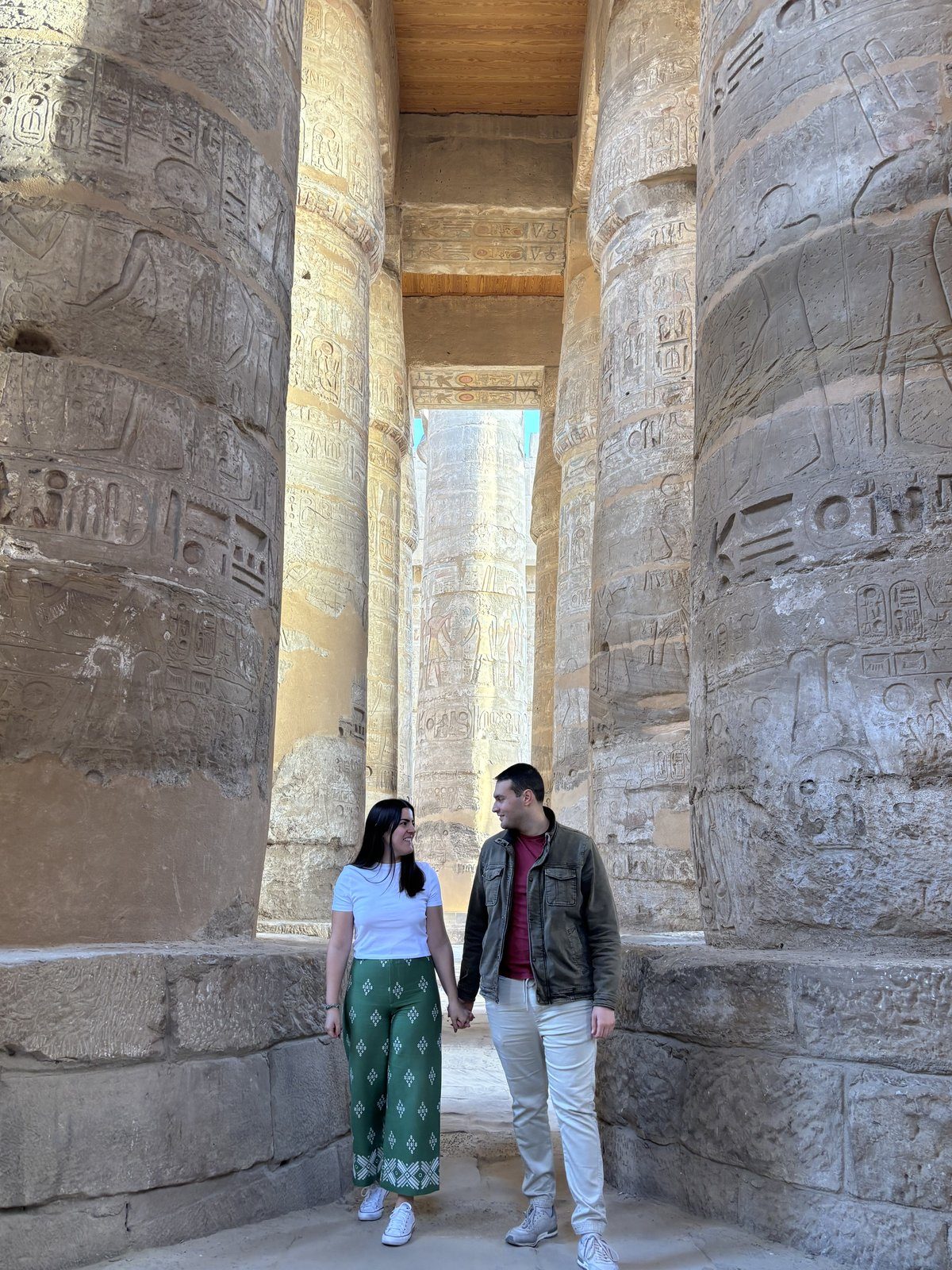 Moni y Adri entre las columnas gigantes de la Sala Hipóstila del Templo de Karnak cubiertas de jeroglíficos
