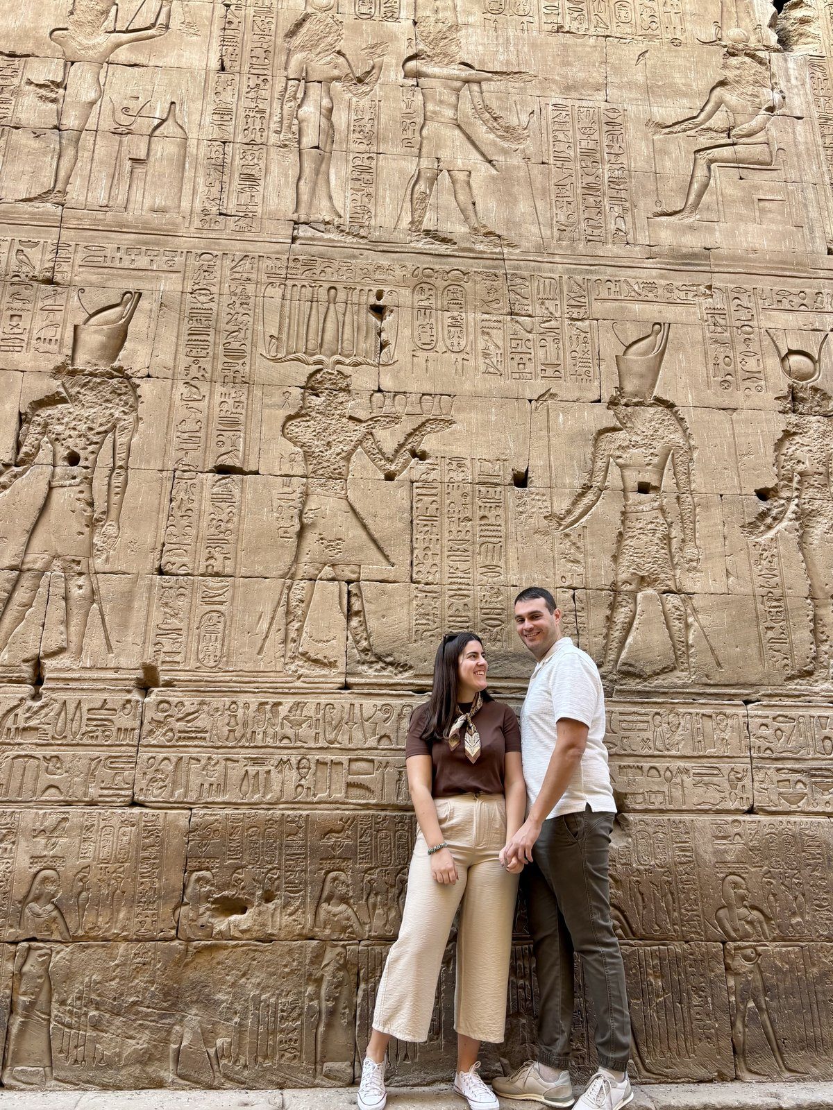Moni y Adri ante un muro cubierto de bajorrelieves y jeroglíficos con dioses del Antiguo Egipto