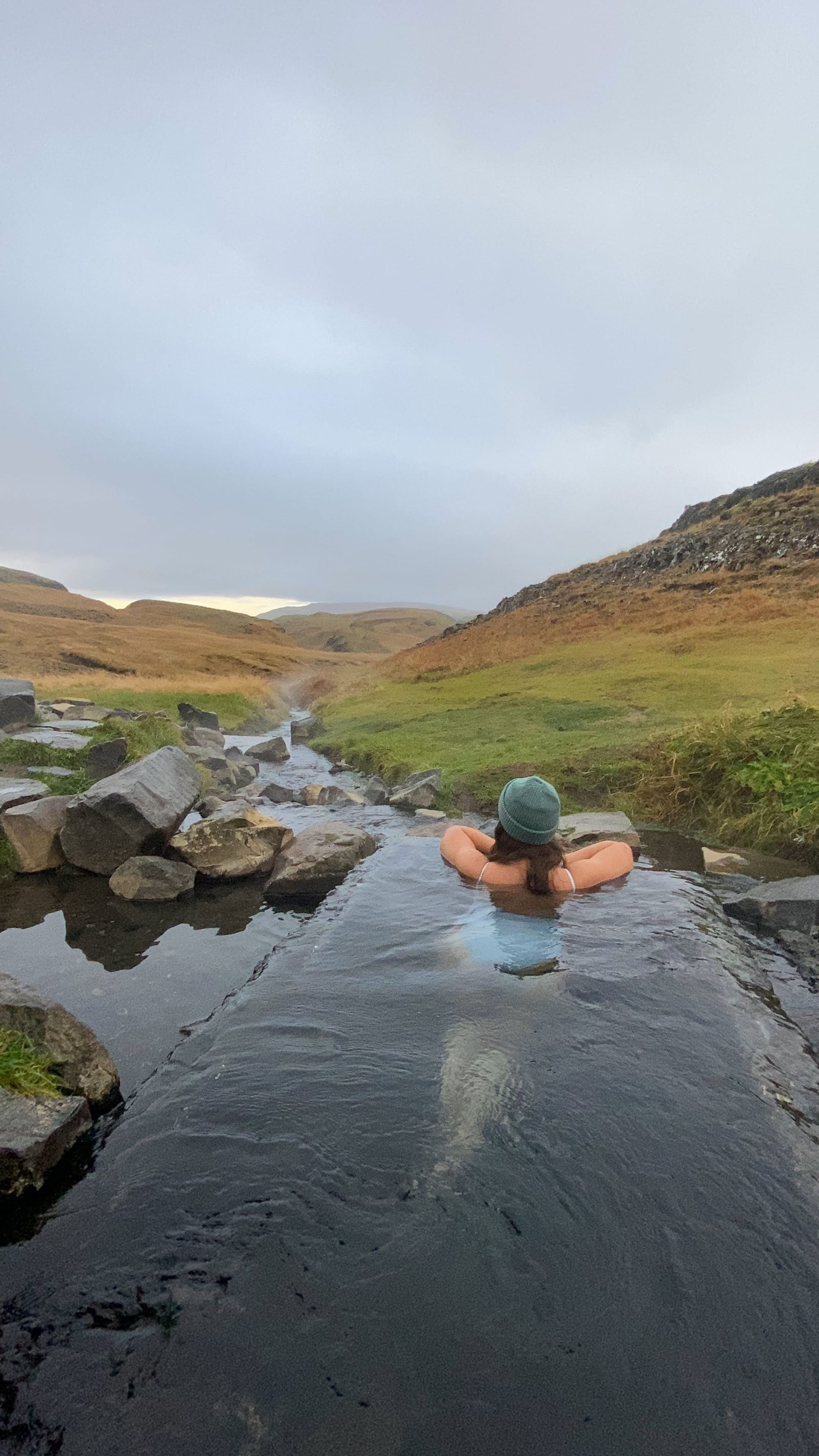 Baño en aguas termales naturales en Islandia rodeado de paisaje verde
