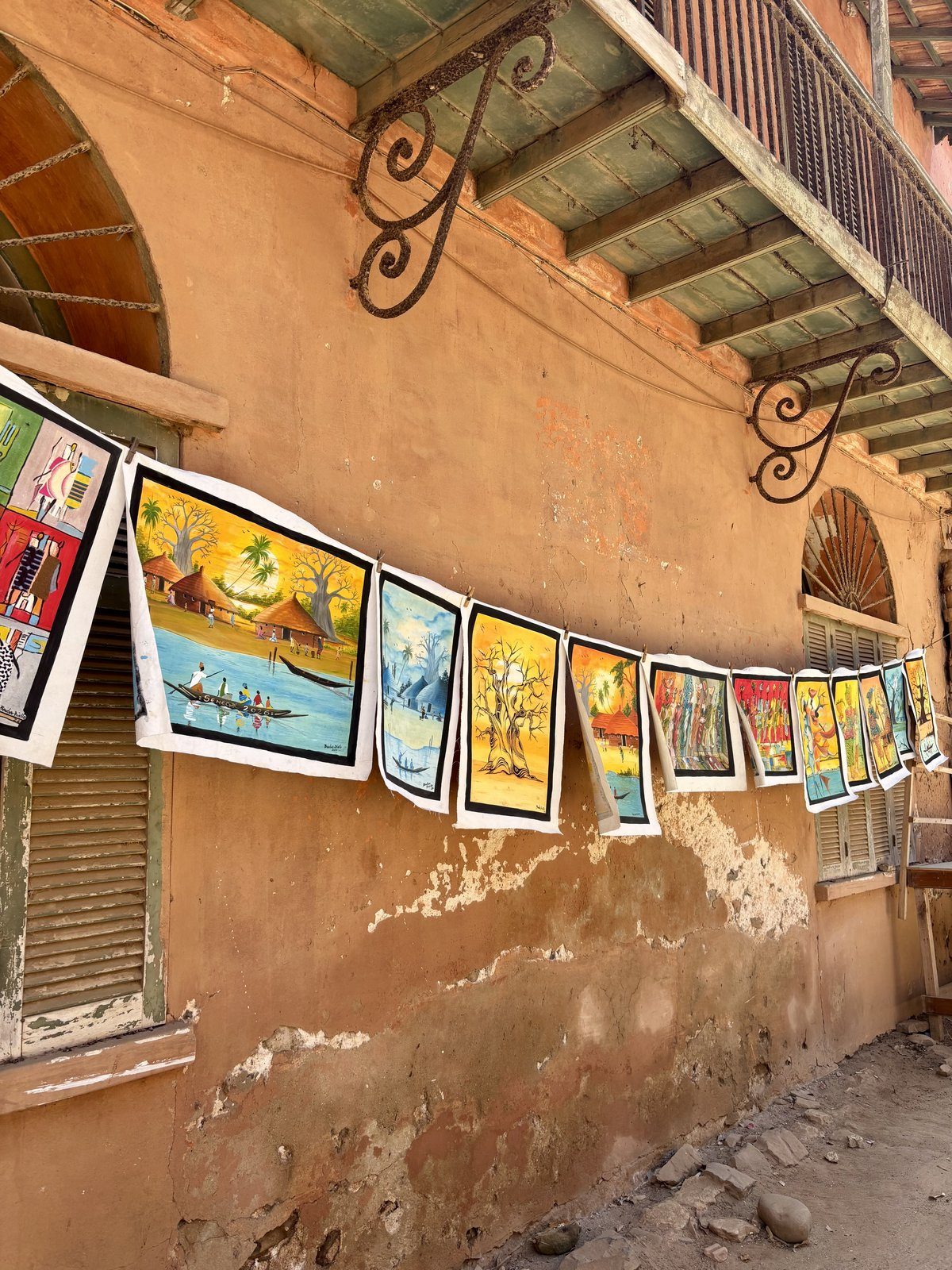 Cuadros de arte africano colgados en la fachada colonial de Saint Louis, Senegal