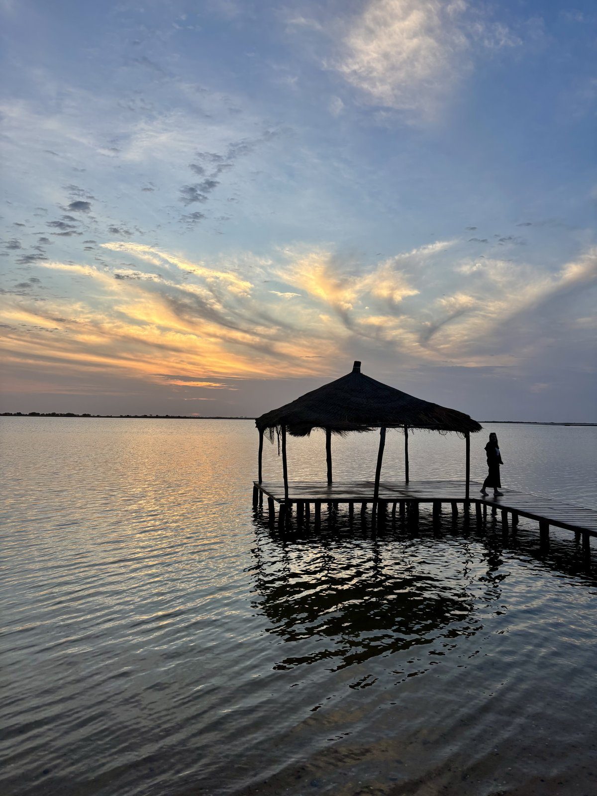 Atardecer sobre el Delta del Saloum con embarcadero de paja en Palmarin, Senegal